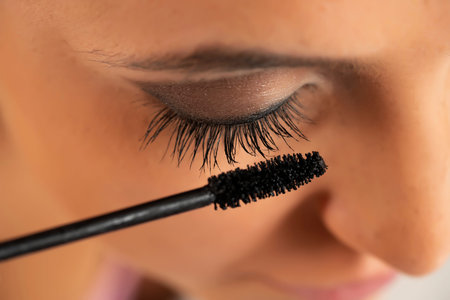 Close up crop of a woman applying mascara