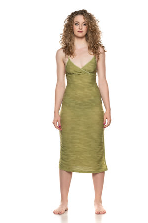 young and tall beautiful barefoot woman in a summer dress on a white studio  backgroundの写真素材