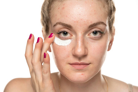 Close up potraiit of a young woman applying cosmetics product under the eye.の写真素材