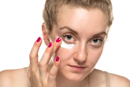 Close up potraiit of a young woman applying cosmetics product under the eye.の写真素材