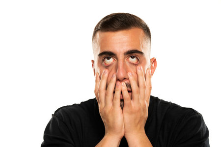 Portrait of disappointed srustrated young man on a white studio background