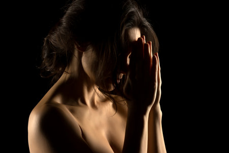 Silhouette of young prying woman on black studio backgroundの写真素材