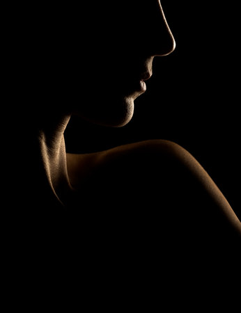 Sensual portrait silhouette of beautiful woman in backlight on a black studio backgroundの写真素材