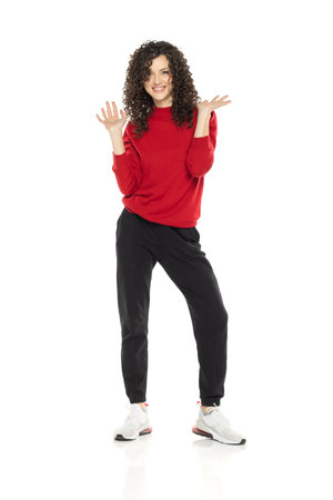 Young curly happy woman posing on white studio background.の写真素材