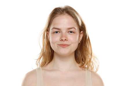 Portrait of young beautiful blonde woman with no makeup on white studio backgroundの写真素材