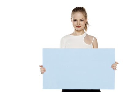 Banner of young happy blonde woman feeling happiness and holding blue Empty white canvas frame for text or advertising isolated on white studio backgroundの写真素材