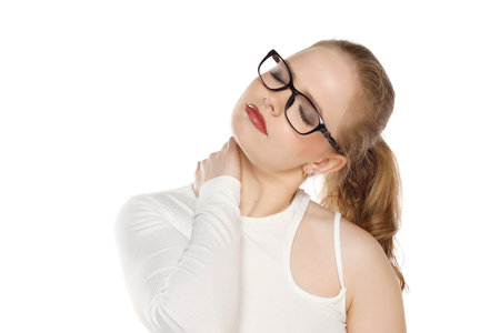 beautiful young woman with glasses has a pain in the neck isolated on white studio backgroundの写真素材