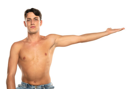 Muscular man with his arm outstretched. topless young fashion model with his hand in the air . Isolated on a white studio backgroundの写真素材