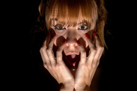 Portrait of scared young woman of something in the dark