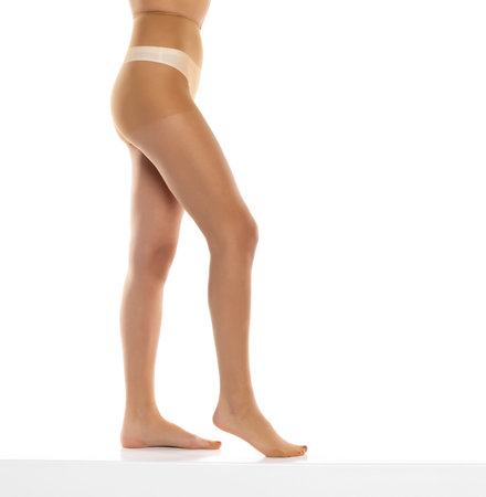 Woman wearing tights isolated on white, closeup of legs on a white studio background. Profile, side viewの写真素材