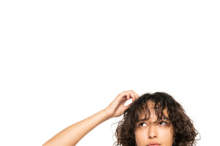 closeup portrait headshot cropped face above lips of cute puzzled woman looking up isolated on white studio wall background with copy space above head. Human face expressions, emotionsの写真素材