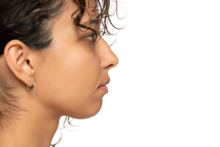 close up, profile, side view of beautiful young indian woman without makeup on a white studio backgroundの写真素材