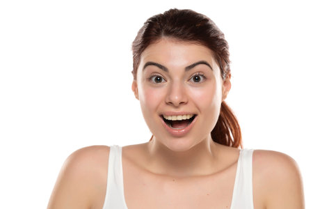 a young happy redhead woman without makeup with long hair on a white studio backgroundの写真素材