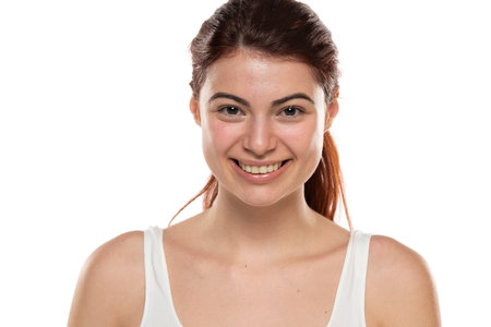 a young happy redhead woman without makeup with long hair on a white studio backgroundの写真素材