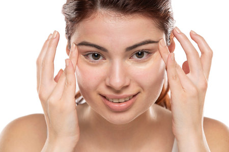 Woman  applying concealer on flawless fresh skin, doing make up. Girl  put corrector under eye area. Beauty face, skin care.の写真素材
