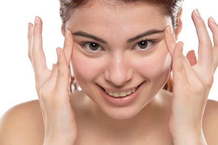 Woman  applying concealer on flawless fresh skin, doing make up. Girl  put corrector under eye area. Beauty face, skin care.の写真素材