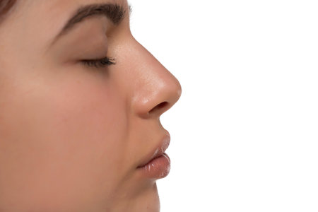 Closeup nose and mouth of a young woman on a white studio backgroundの写真素材