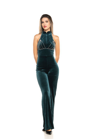 Fashionable young smiling brunette woman with long legs wearing One Piece Jumpsuits trousers, on a white studio backgroundの写真素材