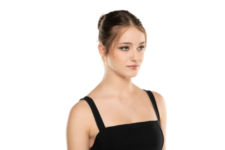 Elegant Beauty: Portrait of a Young Woman with Makeup and Updo on White Studio Backgroundの写真素材