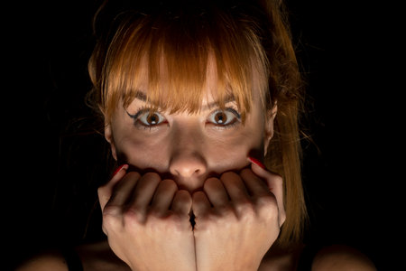 Portrait of scared young woman of something in the darkの写真素材