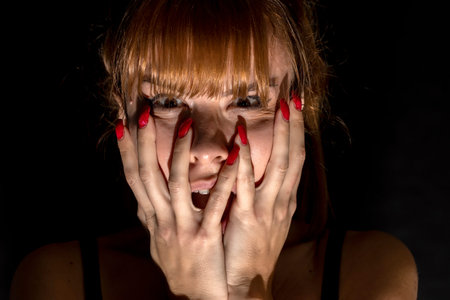 Portrait of scared young woman of something in the dark