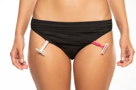 shaving blades in panties. girl health and intimate hygiene. Beautiful Woman's body with smooth soft skin in black bikini panties. Epilation Concepts. white studio backgroundの写真素材