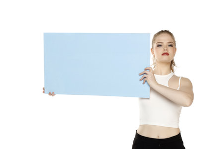 Banner of young serious blonde woman feeling happiness and holding blue Empty white canvas frame for text or advertising isolated on white studio backgroundの写真素材