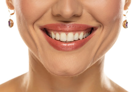Close-up of a woman's mouth, capturing a confident smile and perfect natural teeth and lipsの写真素材