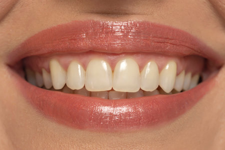Close-up of a woman's mouth, capturing a confident smile and perfect natural teeth and lipsの写真素材