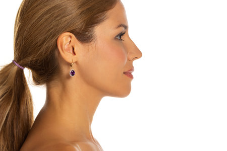 Profile side view of a young beautiful woman with on a white studio backgroundの写真素材