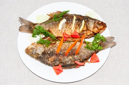 Fresh crucian river fish fried in lemon juice and fresh herbsの写真素材