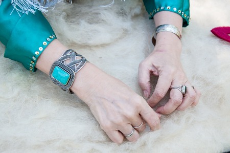 The hands of a Muslim woman working with woolの写真素材