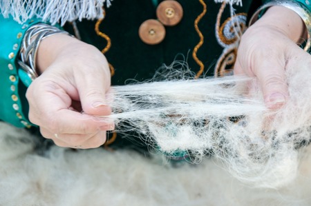 The hands of a Muslim woman working with woolの写真素材