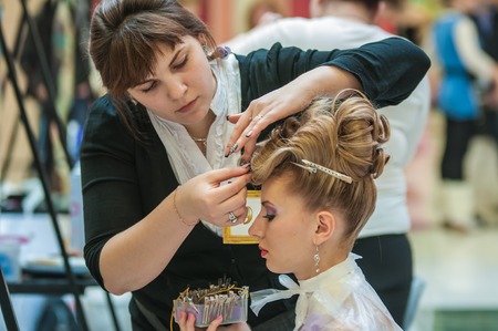 ORENBURG, ORENBURG region, RUSSIA - 6 December 2014: Contest of hairdressers in the nomination wedding hairstyle. Hairdresser makes the wedding hairstyle.のeditorial素材
