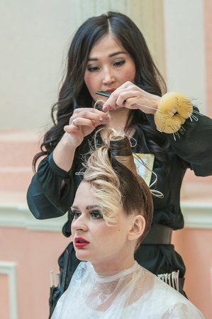 ORENBURG, ORENBURG region, RUSSIA - 6 December 2014: Contest of hairdressers in the nomination wedding hairstyle. Hairdresser makes the wedding hairstyle.のeditorial素材