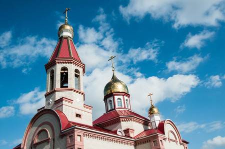 The dome of the Christian Church against the background of blue sky and white cloudsの写真素材
