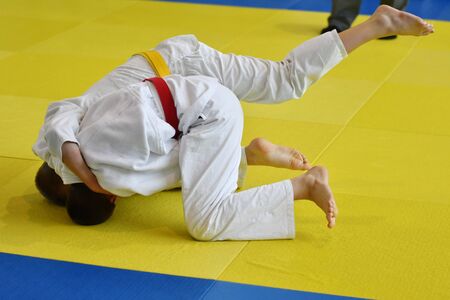 Two Boys judoka in kimono compete on the tatamiの写真素材