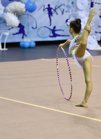 Girl performs mandatory exercises in rhythmic gymnasticsの写真素材