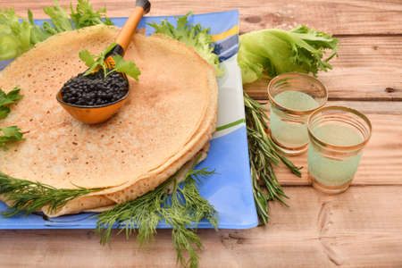Pancakes with black caviar and fresh herbsの写真素材