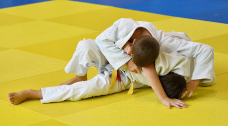 Two Boys judoka in kimono compete on the tatamiの写真素材