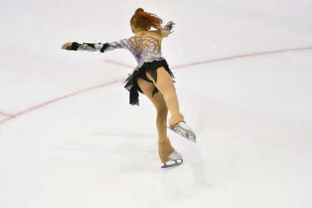 Girl figure skater rolls on a skating rink with artificial iceの写真素材