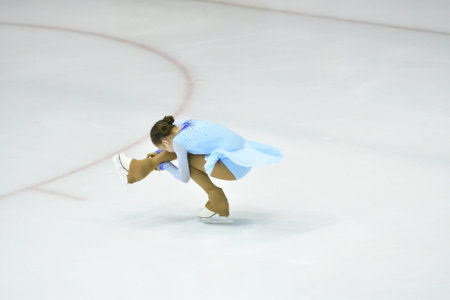 Girl figure skater rolls on a skating rink with artificial ice