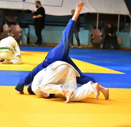 Two boys fighter judoka in kimono compete on the tatamiの写真素材