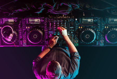 Handsome DJ playing on CD players during party.の写真素材