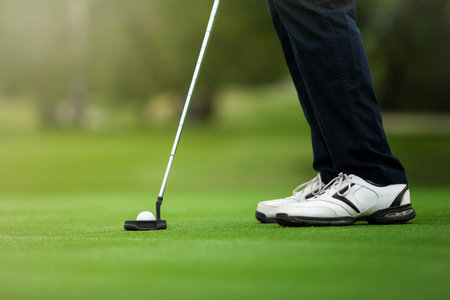 Golfer preparing for a putt on the green during golf course.