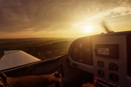 Close up of small planes cockpit in the air. During beautiful sunset.の写真素材