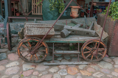 Old agricultural cart, with food basket, standing near the hangar.