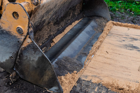 Fragment of the excavator. Repair work on the street of a residential quarter.