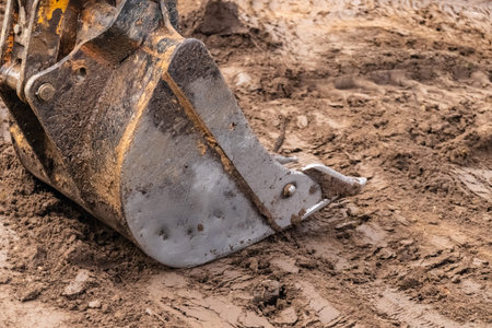 Bucket of excavator at work, construction machinery. Detail.