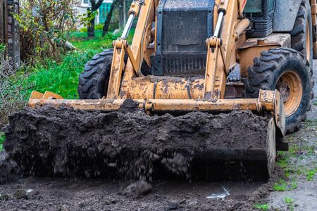 Fragment of the excavator. Repair work on the street of a residential quarter.の写真素材